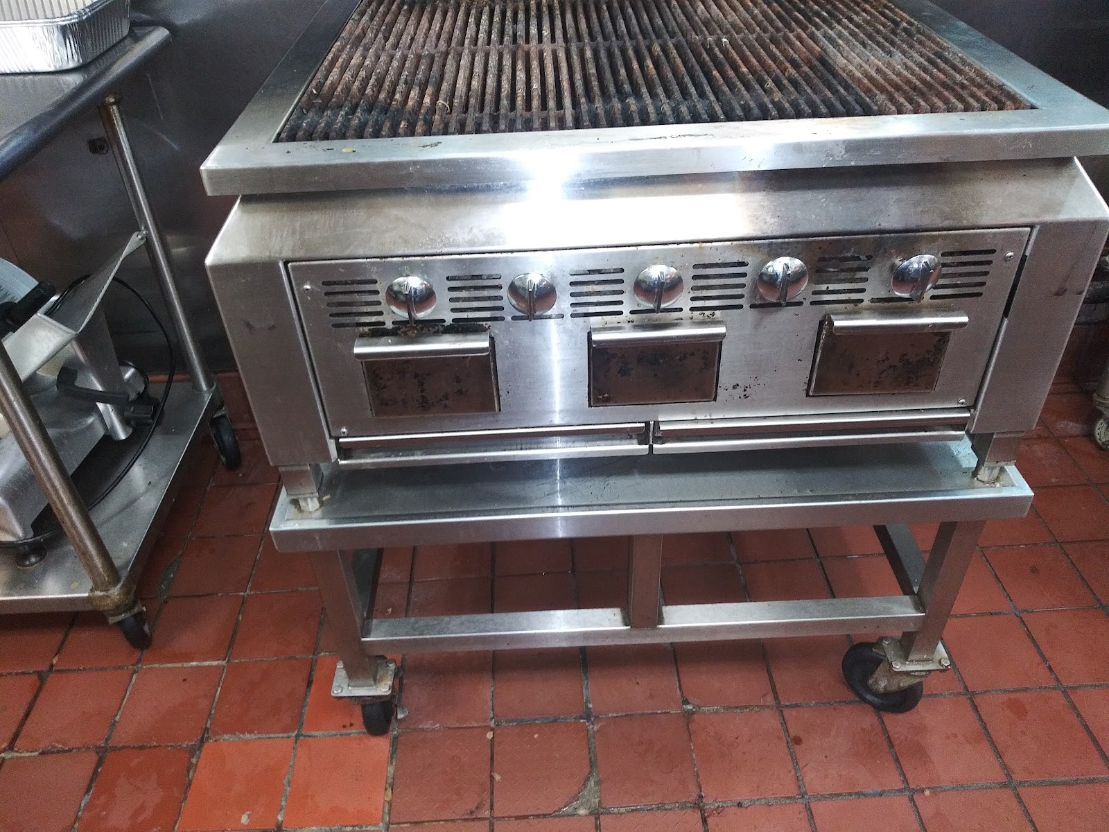Commercial charbroiler on caster stand in a stainless prep kitchen
